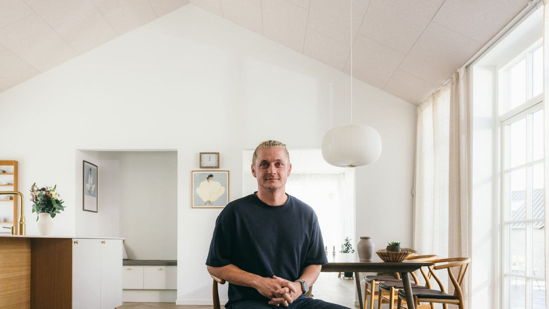 Boligejer i køkken-alrum med ARKU akustikpaneler monteret direkte på loft med kip som alternativ til traditionelt gipsloft