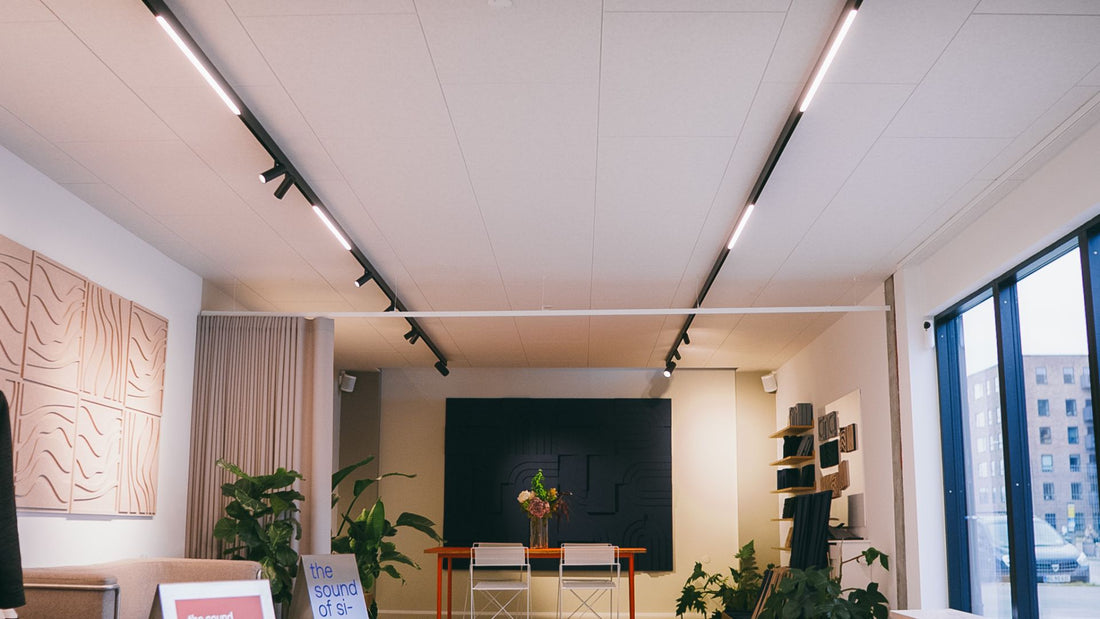 Akustikpaneler monteret i fuldt dækkende loft med integreret skinnebelysning i ARKU showroom