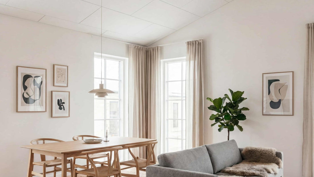 Akustikpaneler monteret på loft i lys stue med spisebord og sofa, der viser det færdige resultat af et akustikloft til gør-det-selv montering