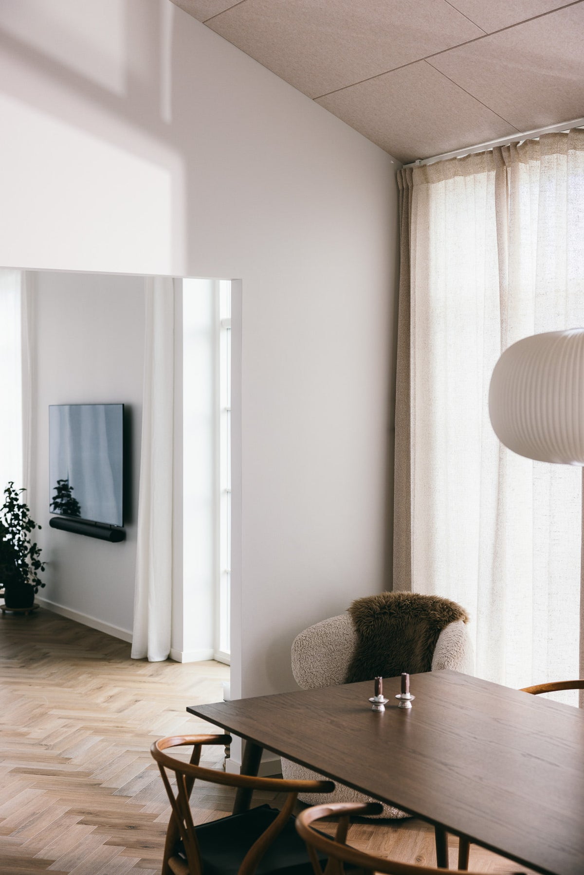 Arku rektangulært akustikpanel i lys sand. Køkkenalrum i forbindelse med stue med paketgulv i sammenspil med lofter i rolig lys beige farve.