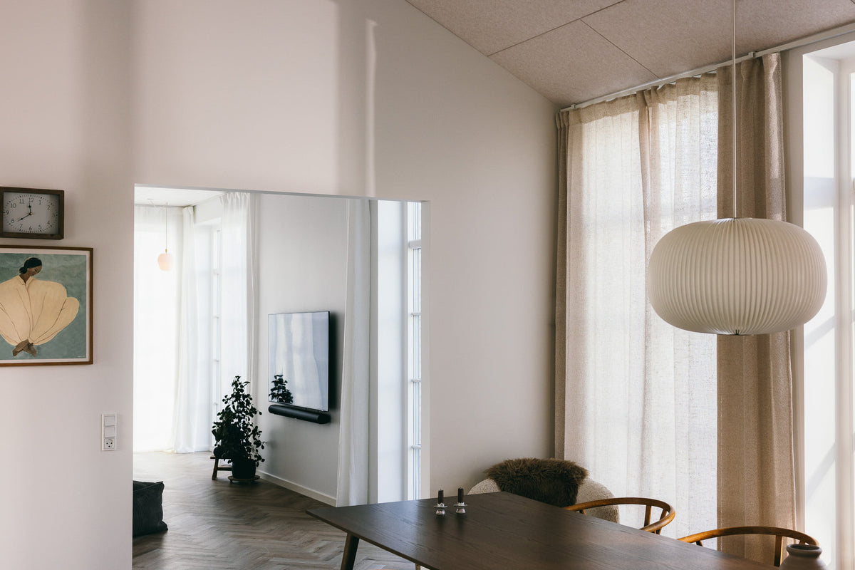 Arku rektangulært akustikpanel i lys sand i moderne stue i ny nordisk stil. Rolige omgivelser i køkkenalrum med loft til kip.