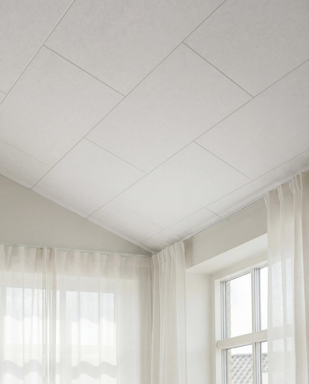 Arku akustikpanel i råhvid til moderne bolig. Loft til kip med god akustik. Lyse luftige rum med lette gardiner.