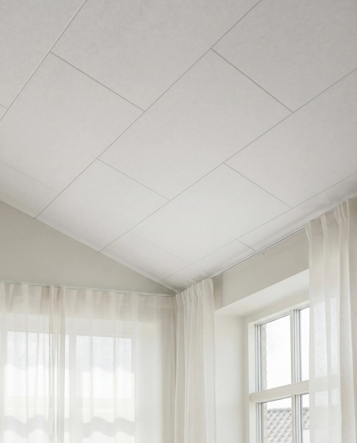 Arku akustikpanel i råhvid til moderne bolig. Loft til kip med god akustik. Lyse luftige rum med lette gardiner.
